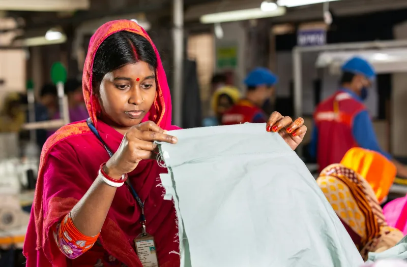 A garment worker folding fabric in a workshop