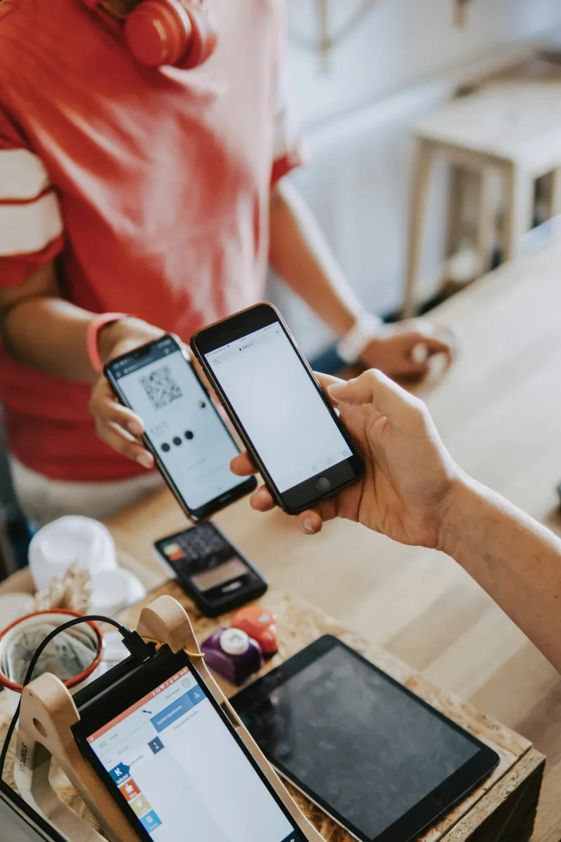 Two phones held side by side to make a payment
