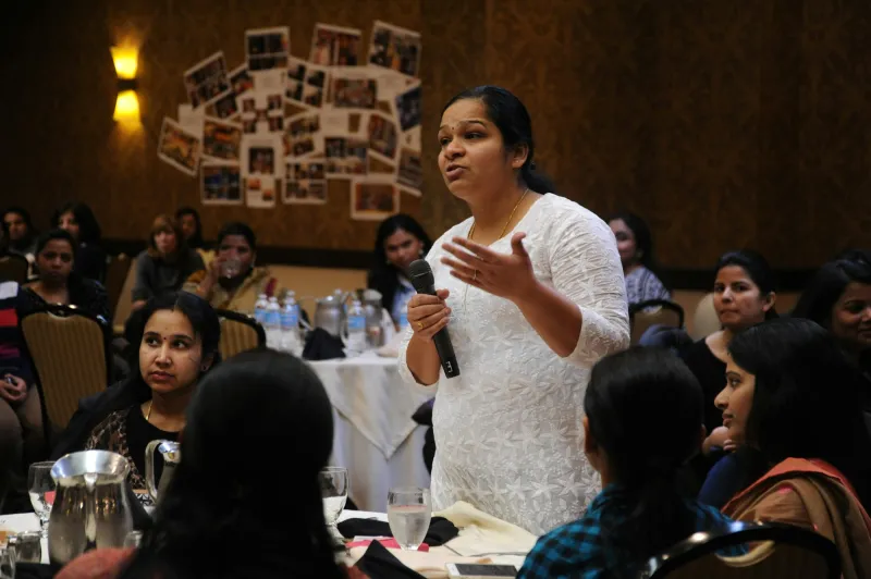 A woman speaking to a seated audience at a workshop